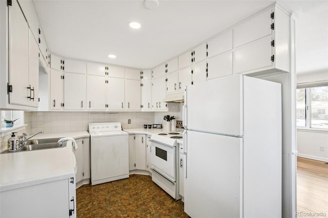 kitchen featuring sink, white appliances, backsplash, white cabinets, and washer / dryer