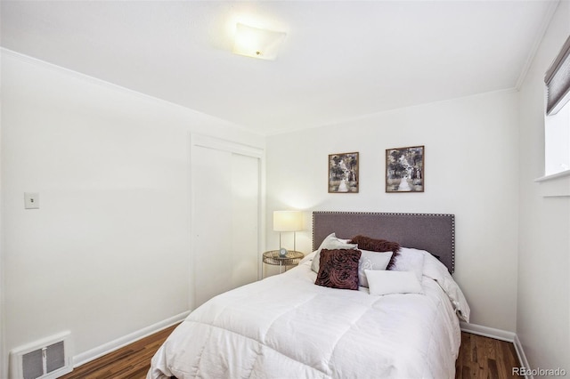 bedroom featuring dark hardwood / wood-style floors and a closet