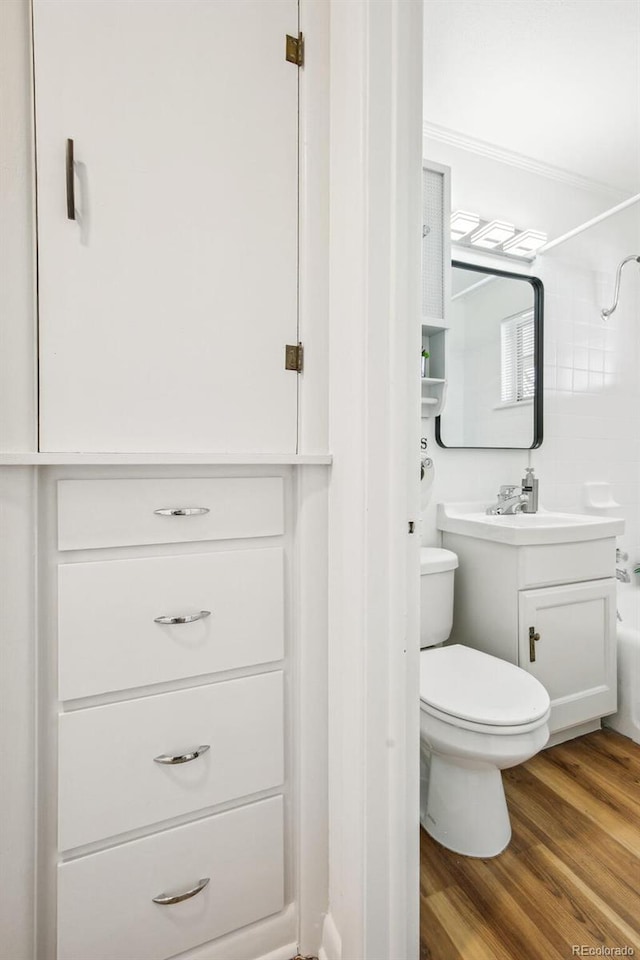 full bathroom featuring toilet, shower / tub combination, vanity, ornamental molding, and hardwood / wood-style floors