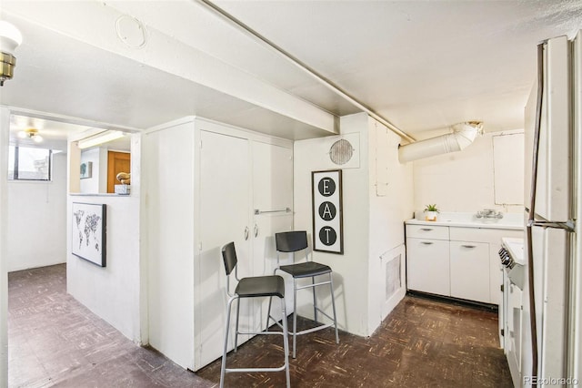 kitchen featuring white fridge and white cabinets