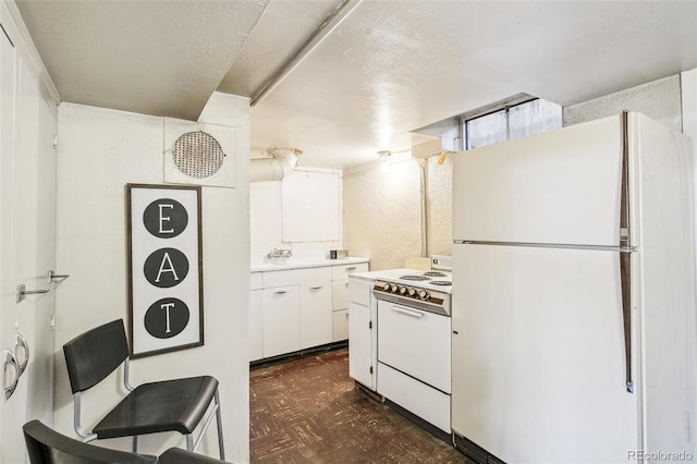 kitchen featuring white cabinetry and white appliances