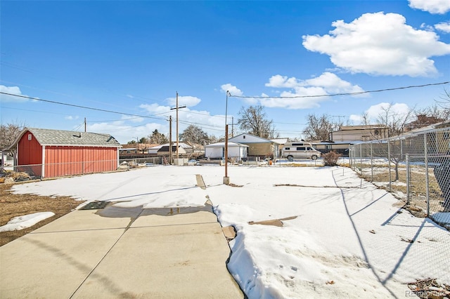 yard covered in snow with an outbuilding