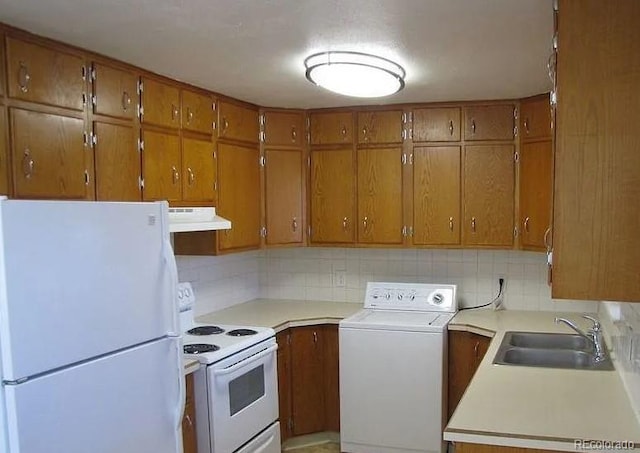 kitchen with washer / clothes dryer, tasteful backsplash, sink, and white appliances