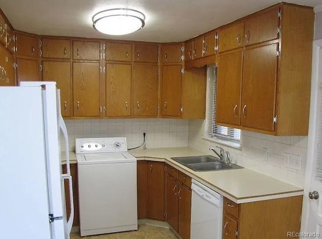 kitchen featuring washer / clothes dryer, white appliances, sink, and backsplash