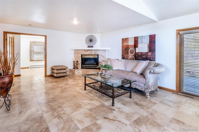 living area with a high end fireplace, a baseboard radiator, and baseboards