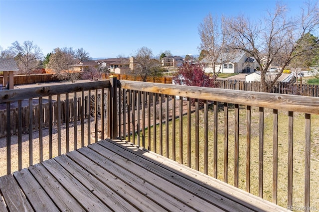 wooden terrace with a residential view and a fenced backyard
