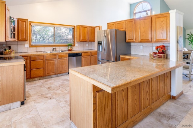 kitchen with tile countertops, high vaulted ceiling, a peninsula, appliances with stainless steel finishes, and a sink
