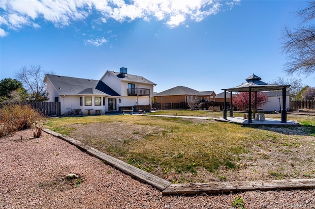 rear view of property with a gazebo, a patio, a fenced backyard, and a yard