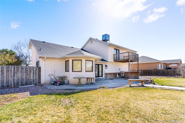 back of property with a yard, stucco siding, and a fenced backyard