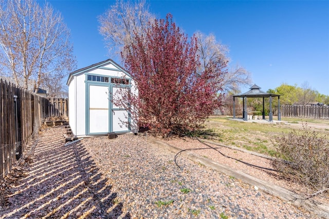 view of yard featuring a gazebo, a shed, a fenced backyard, and an outdoor structure
