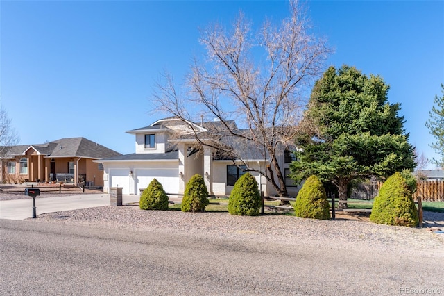 traditional-style house featuring driveway, stucco siding, fence, and a garage
