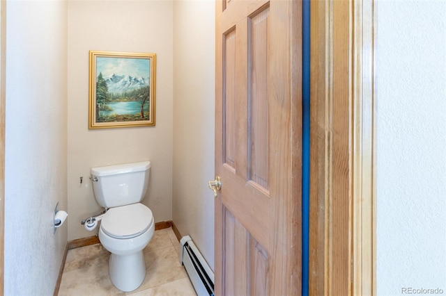 bathroom featuring tile patterned floors, toilet, a baseboard heating unit, and baseboards