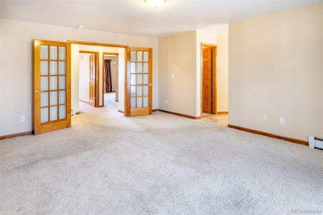 empty room with light carpet, french doors, and baseboards