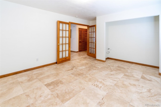 unfurnished room featuring french doors and baseboards