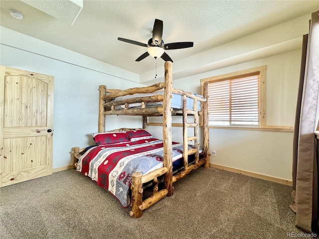 carpeted bedroom with ceiling fan, a textured ceiling, and baseboards