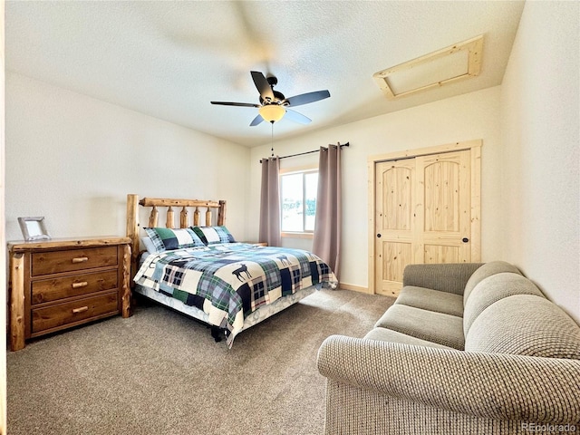 bedroom with attic access, baseboards, a ceiling fan, a textured ceiling, and carpet flooring