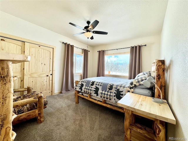 carpeted bedroom with ceiling fan and a textured ceiling