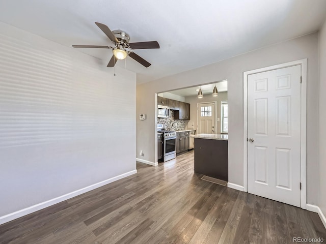 unfurnished living room featuring dark wood-type flooring and ceiling fan