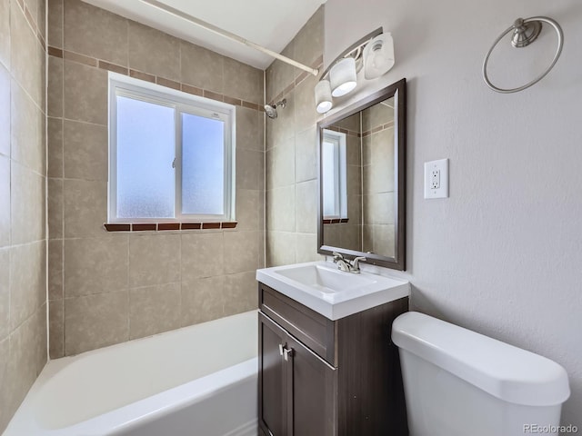 full bathroom with tiled shower / bath, vanity, and toilet