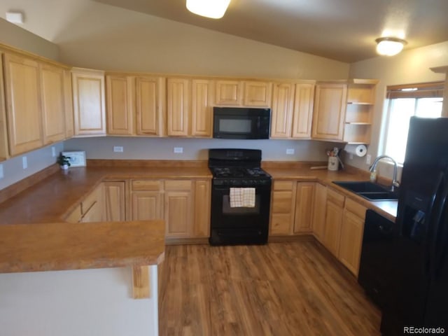 kitchen featuring light brown cabinetry, kitchen peninsula, sink, and black appliances