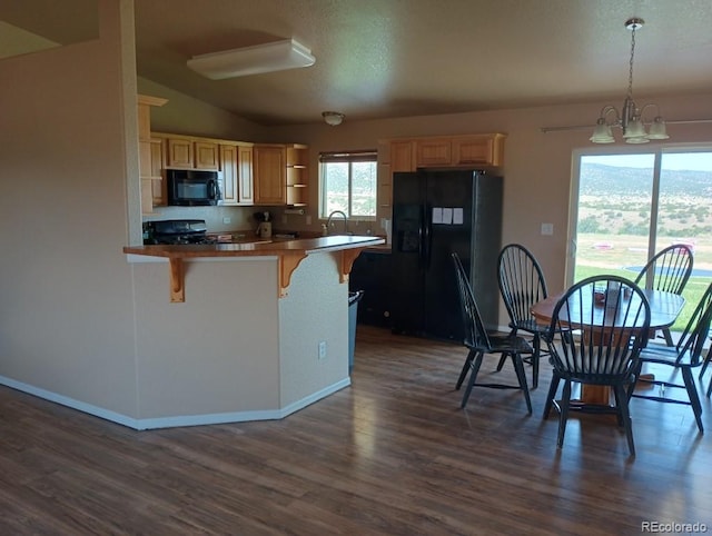 kitchen with dark hardwood / wood-style floors, decorative light fixtures, a breakfast bar area, and black appliances