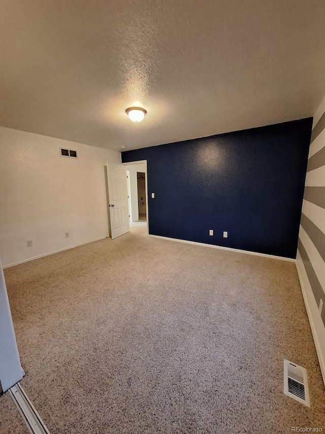 spare room featuring carpet flooring and a textured ceiling