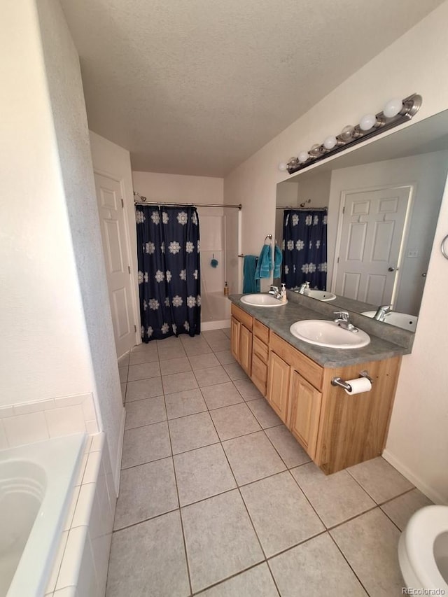 bathroom featuring tile patterned floors, plus walk in shower, vanity, and a textured ceiling