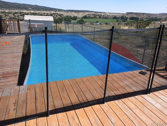 view of swimming pool with a mountain view and a rural view