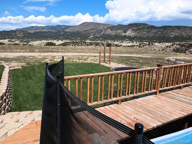 wooden terrace featuring a mountain view and a yard