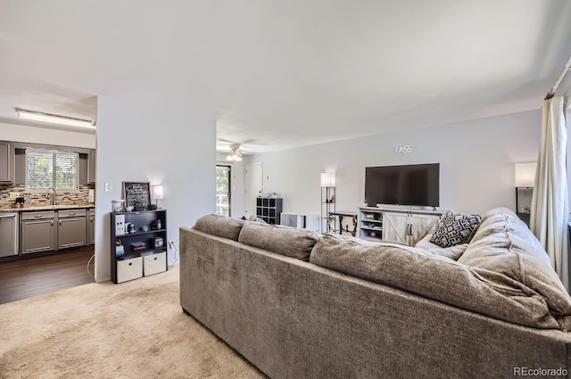 living area featuring light colored carpet and ceiling fan