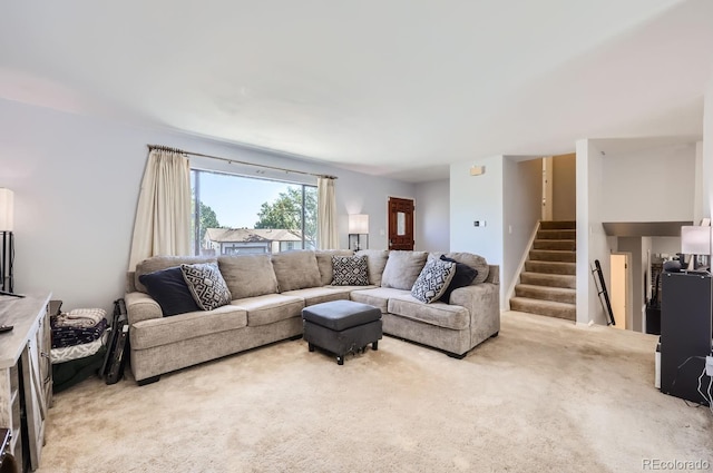 living area featuring stairway and light colored carpet