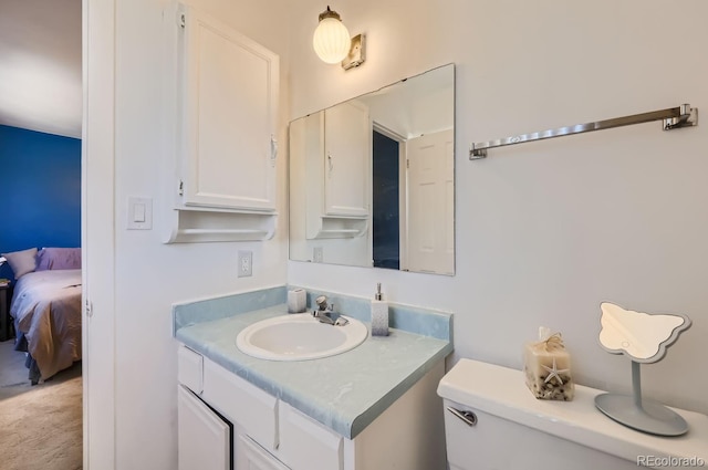 ensuite bathroom with toilet, ensuite bath, and vanity