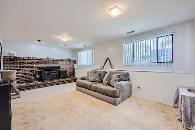 carpeted living room featuring a wood stove, baseboards, and visible vents