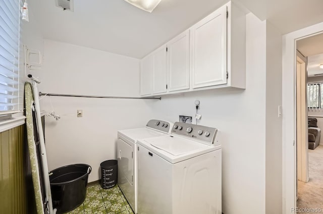 washroom with washer and clothes dryer, cabinet space, and light carpet