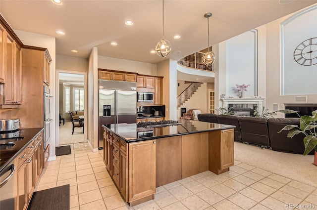 kitchen with a center island, open floor plan, built in appliances, and light tile patterned floors