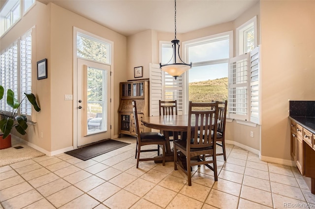 dining room featuring plenty of natural light, baseboards, and light tile patterned floors
