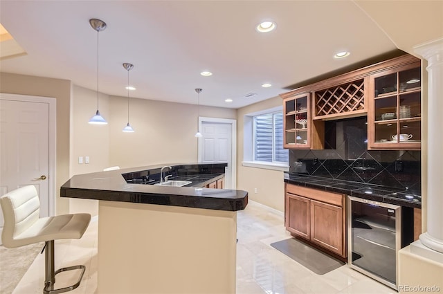 kitchen with beverage cooler, a sink, dark countertops, and tasteful backsplash