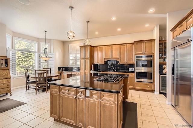 kitchen featuring a center island, appliances with stainless steel finishes, light tile patterned floors, and dark countertops