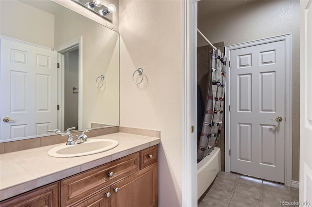 full bath with vanity, tile patterned flooring, a textured wall, and shower / bath combination with curtain