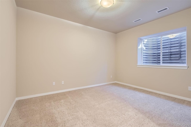 carpeted spare room with baseboards and visible vents