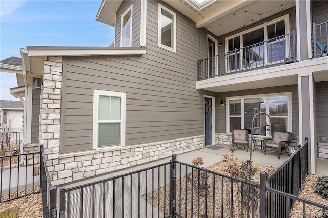 deck with a fenced front yard and a patio