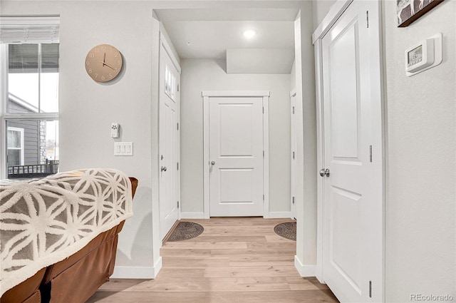 foyer featuring baseboards and light wood-type flooring