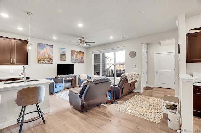 living area featuring light wood finished floors, visible vents, and recessed lighting