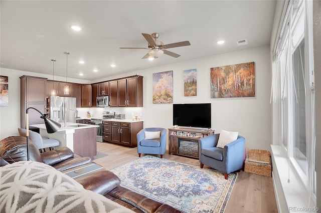 living area featuring light wood-style flooring, recessed lighting, a ceiling fan, and visible vents