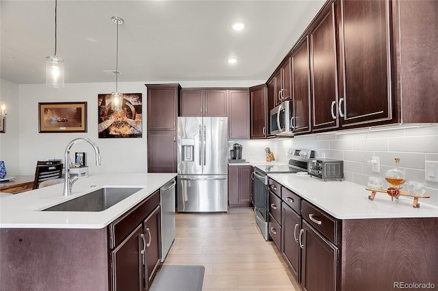 kitchen with a sink, tasteful backsplash, stainless steel appliances, light countertops, and dark brown cabinets