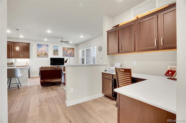 kitchen with built in study area, recessed lighting, ceiling fan, light countertops, and light wood-type flooring