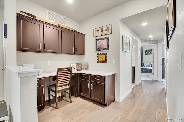 office featuring recessed lighting, light wood-style floors, built in desk, and baseboards