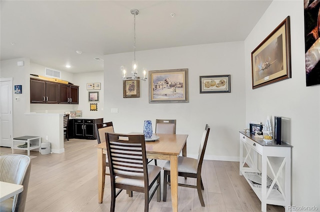 dining space with a chandelier, visible vents, baseboards, and light wood-style floors