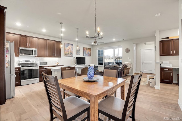 dining room with light wood finished floors, recessed lighting, and ceiling fan with notable chandelier