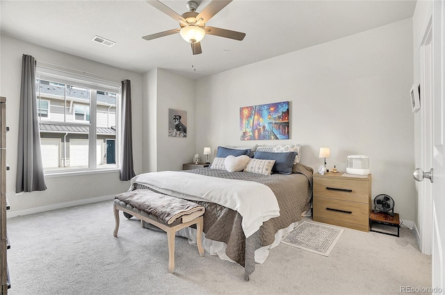 carpeted bedroom with visible vents, baseboards, and a ceiling fan